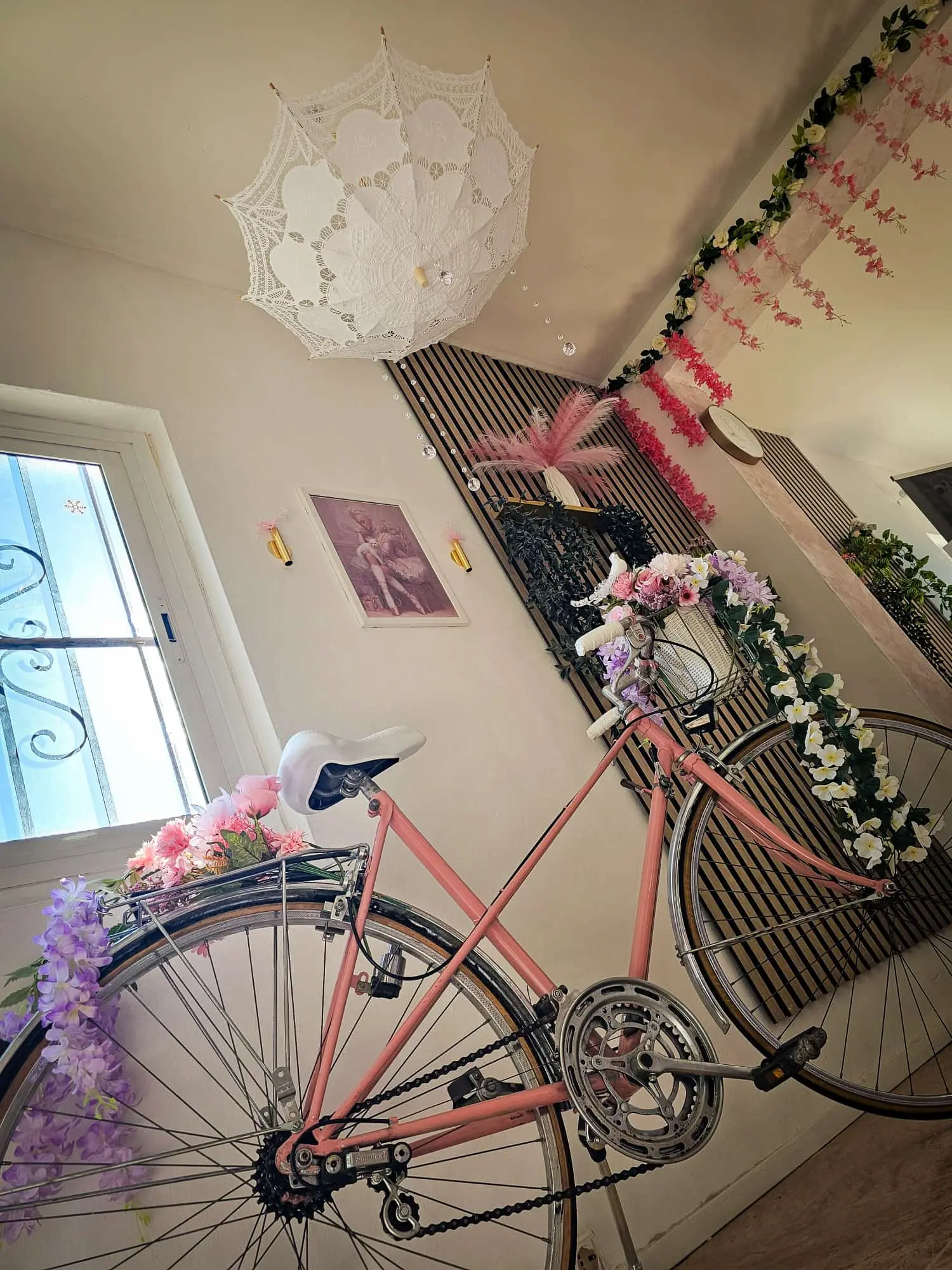 Decoración vintage del salón Iris Nails con bicicleta rosa y flores