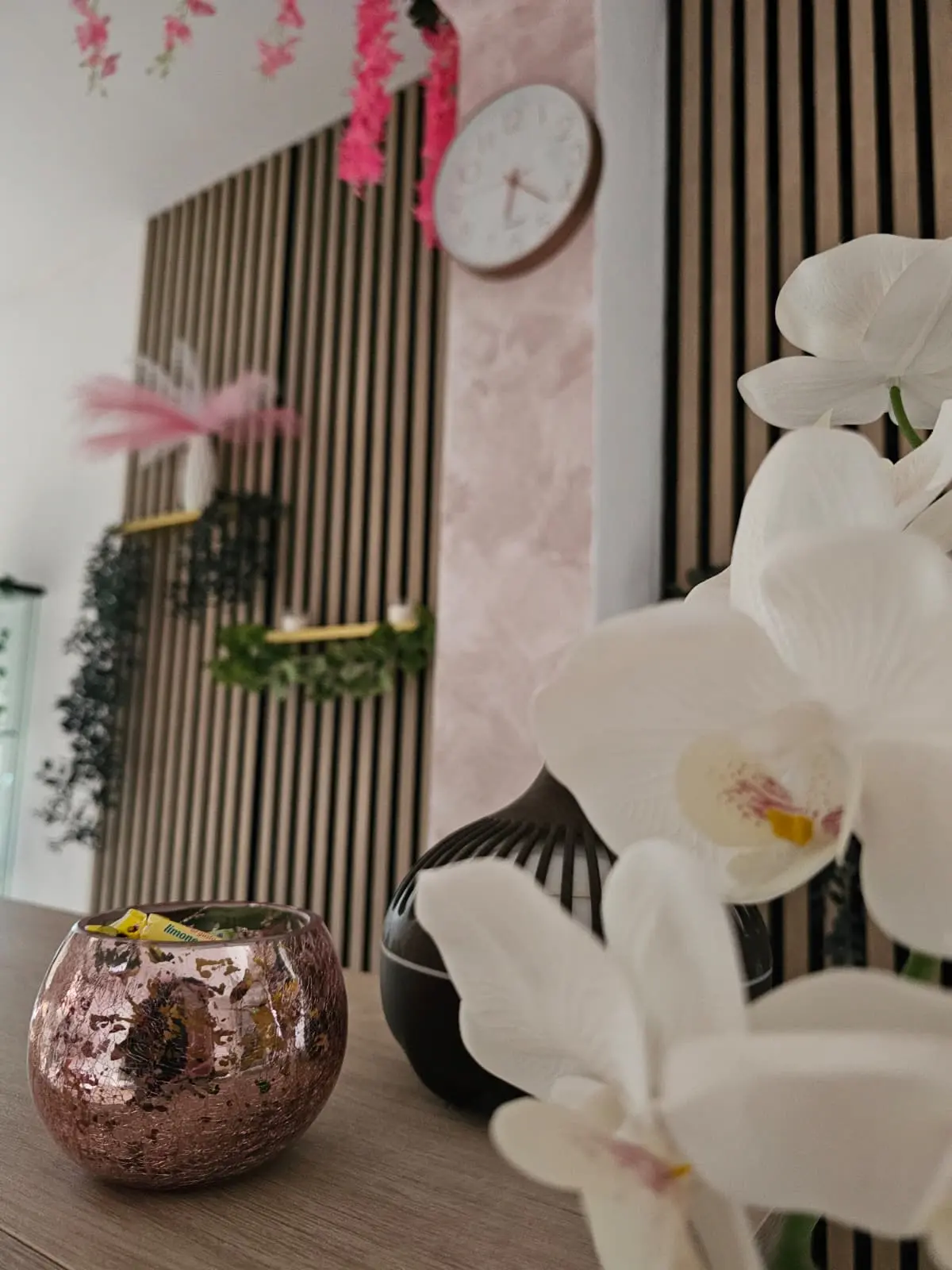 Interior elegante del salón Iris Nails con orquídeas y decoración rosa